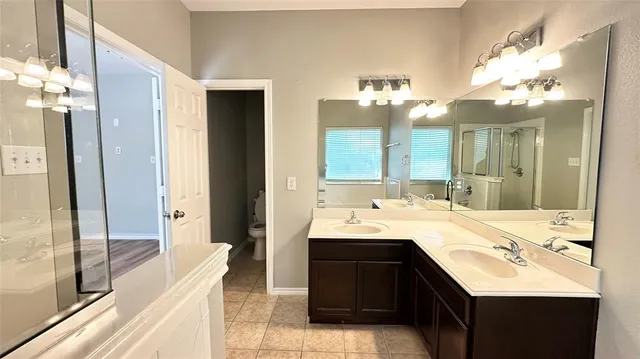 a bathroom with a tub sink and mirror