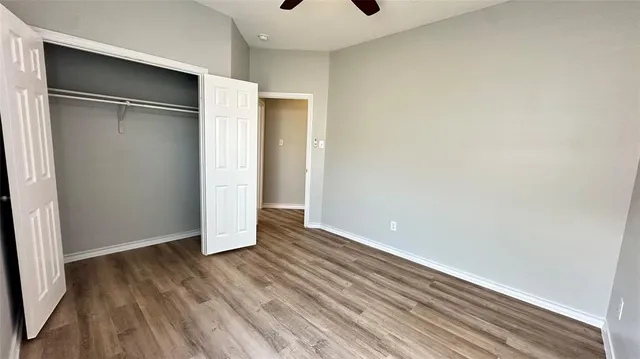an empty room with a ceiling fan and window