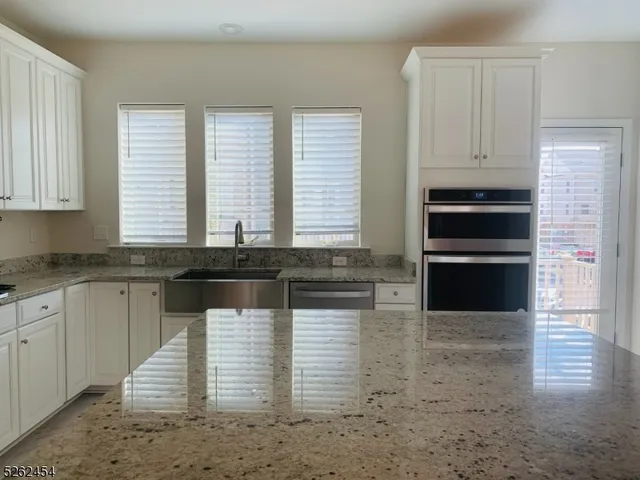 a kitchen with granite countertop a sink and a stove