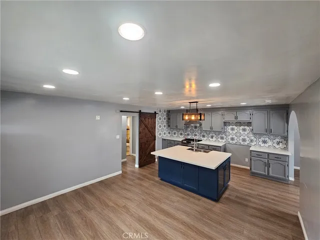 a large room with kitchen island a wooden floor and living room