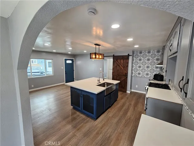 a living room with hard wood floors and a kitchen