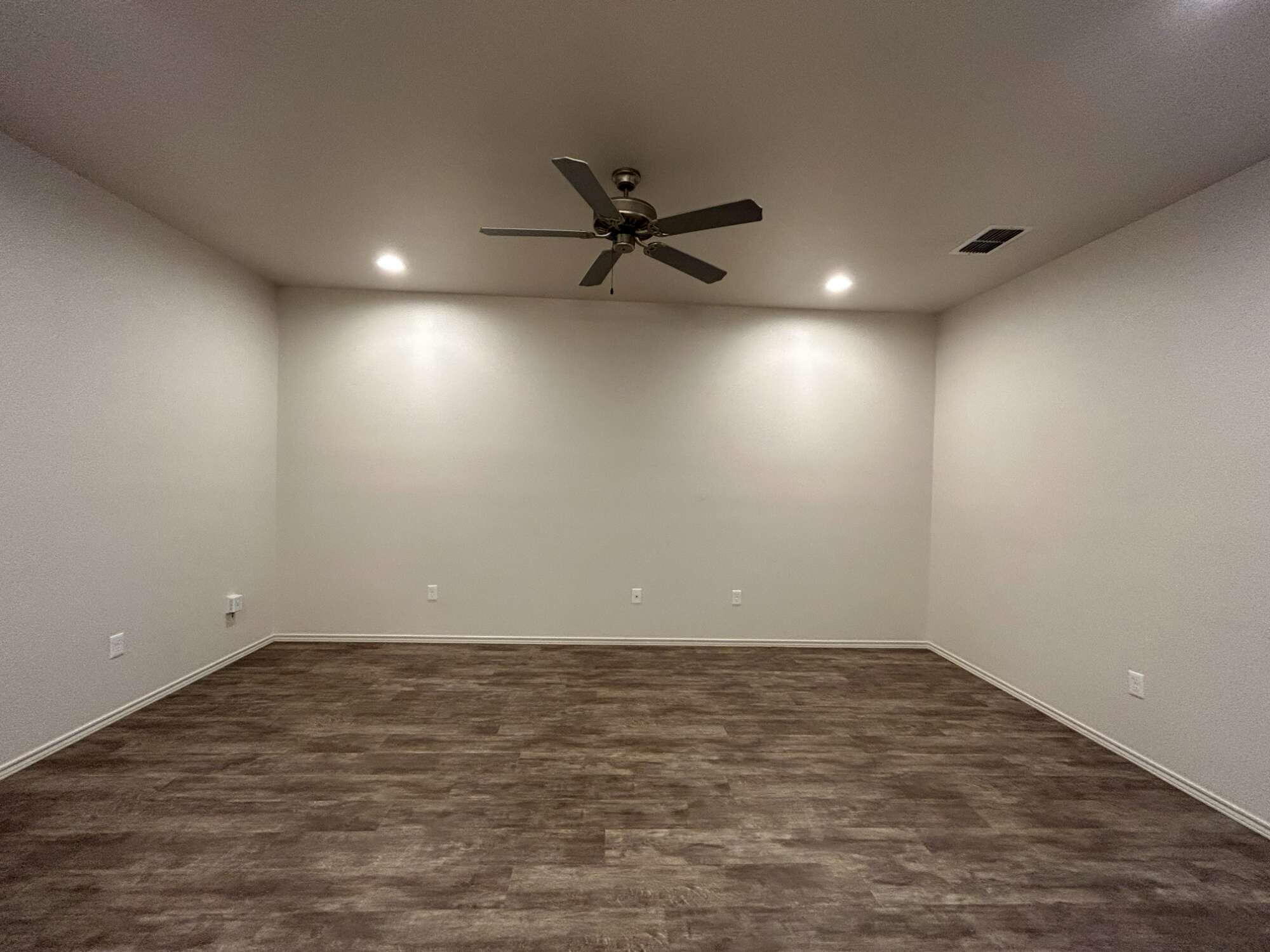 11620 Evanston Avenue Lubbock, TX 79424 - Photo 2 of 11 an empty room with a ceiling fan and kitchen view