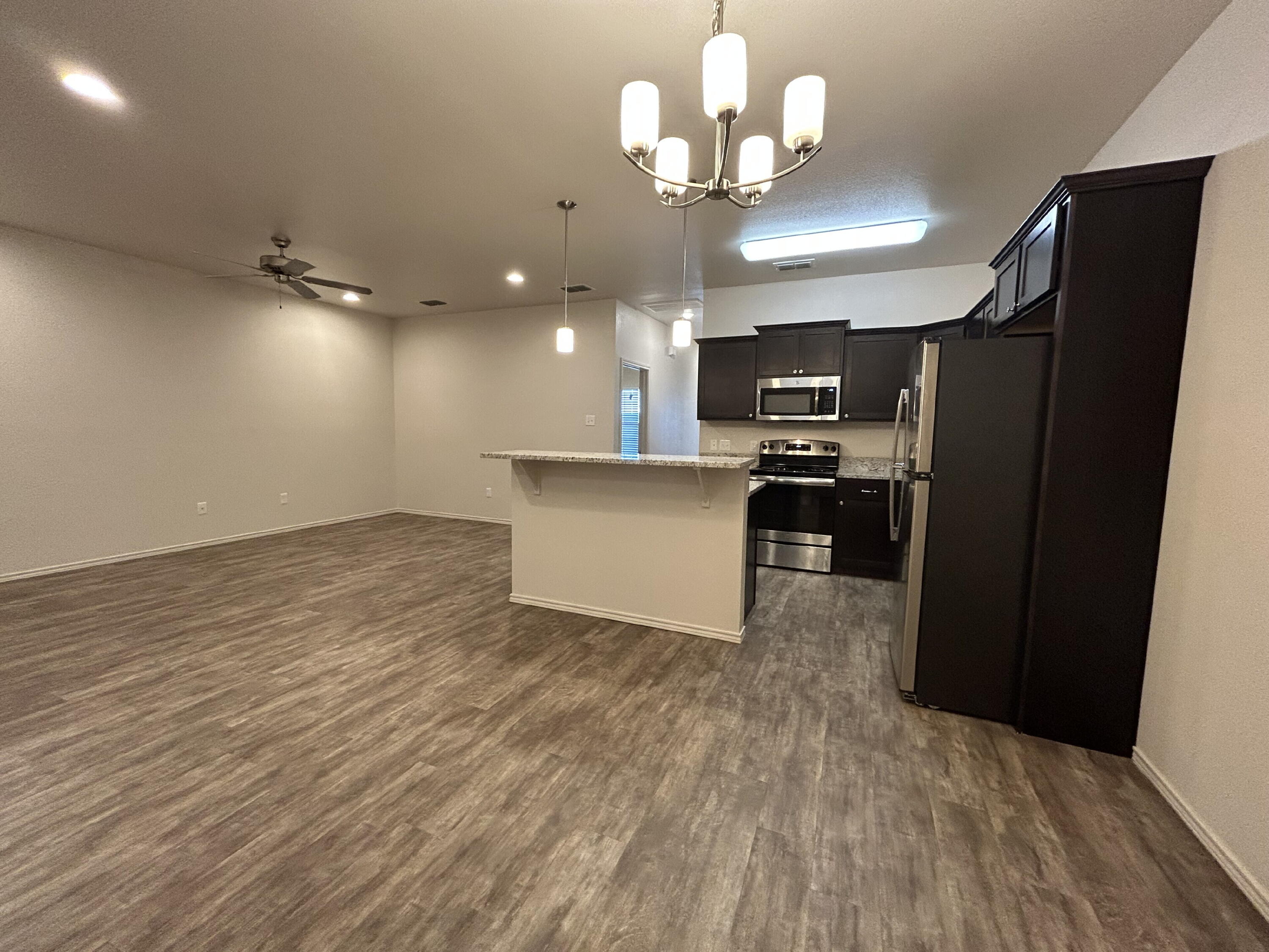 11620 Evanston Avenue Lubbock, TX 79424 - Photo 4 of 11 an open kitchen with wooden floor and stainless steel appliances