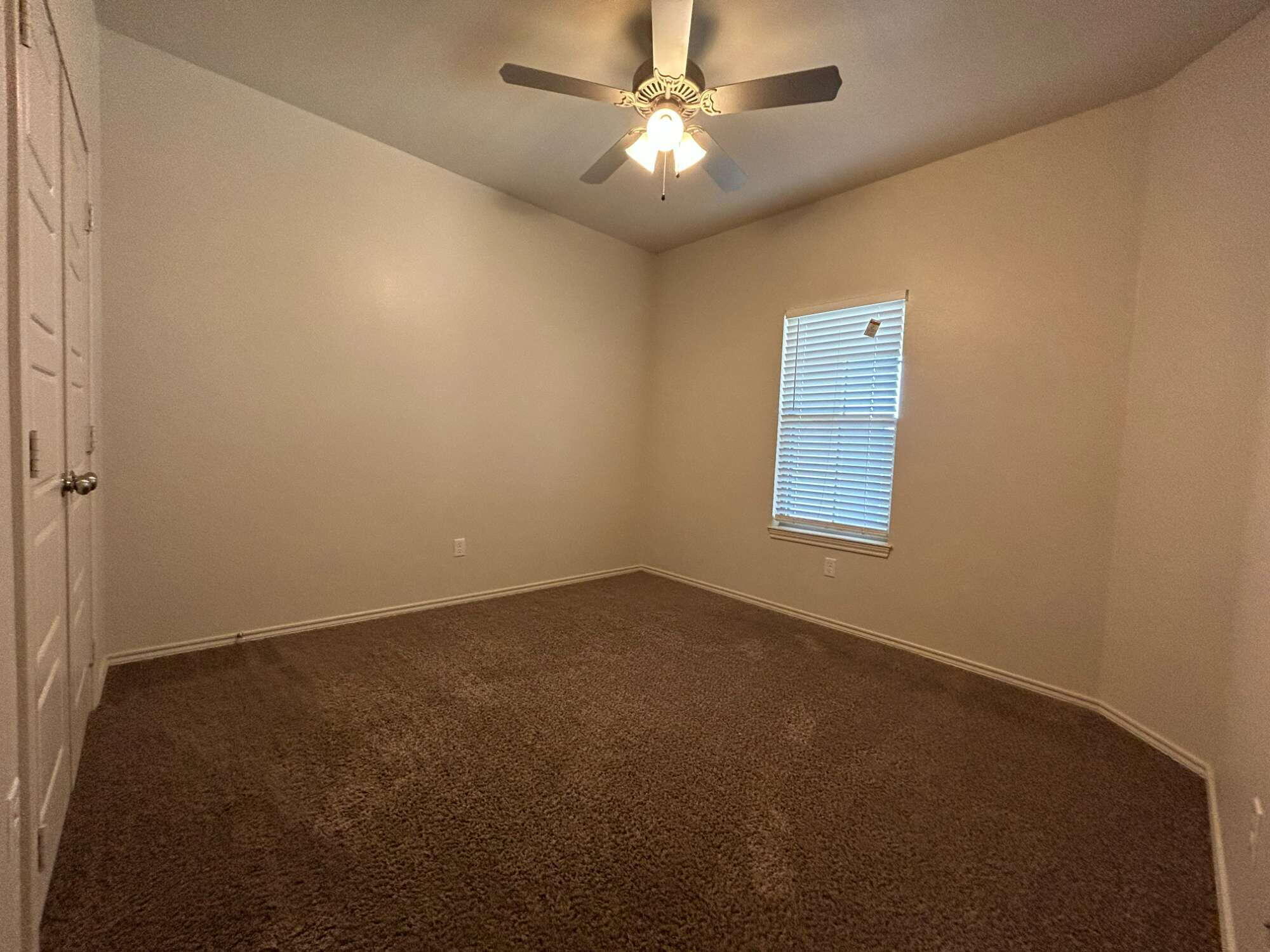 11620 Evanston Avenue Lubbock, TX 79424 - Photo 8 of 11 an empty room with a fan & a window