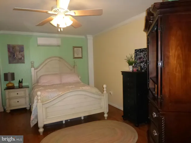 a bedroom with a bed and a flat tv screen on dresser
