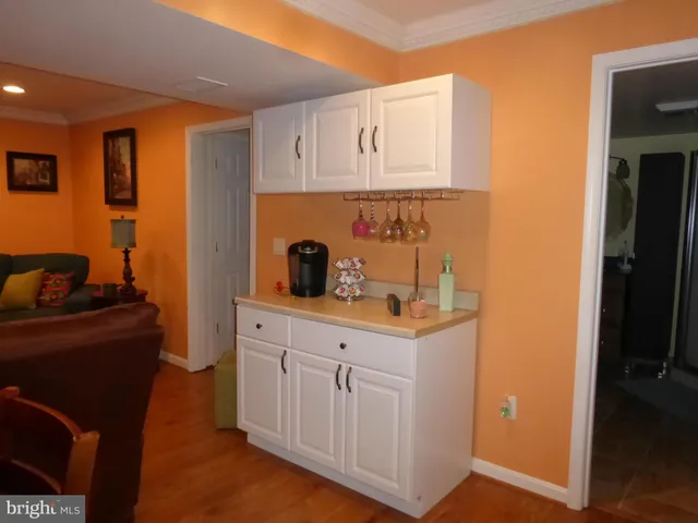 a kitchen with white cabinets and sink