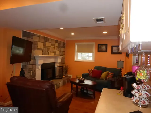 a living room with furniture a flat screen tv and a fireplace