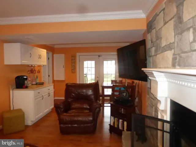 a living room with furniture a dining table and chairs with wooden floor