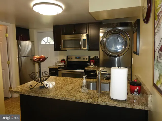 a living room with chairs and kitchen view