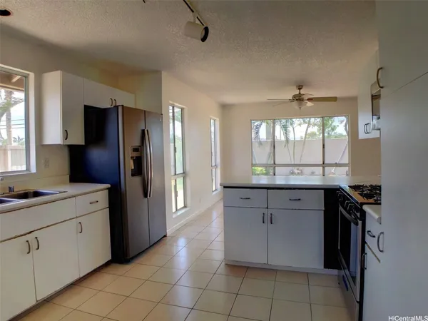 a kitchen with stainless steel appliances granite countertop a refrigerator and a sink
