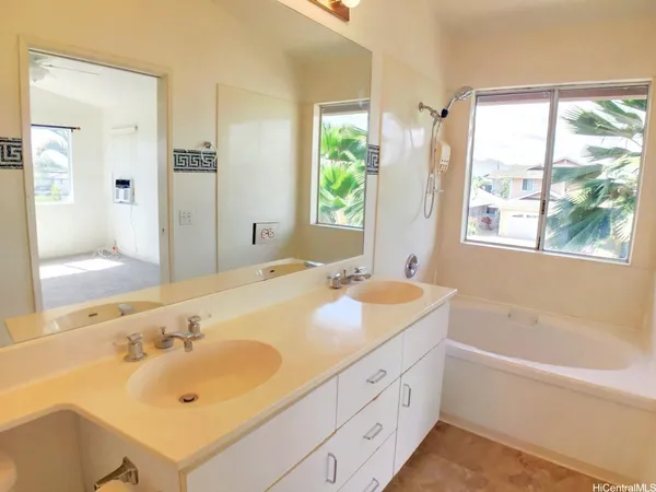 a bathroom with a tub sink and mirror