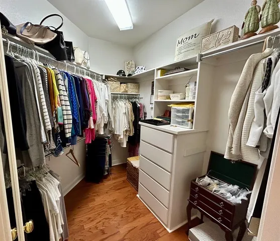 a view of walk in closet with clothes and shoes