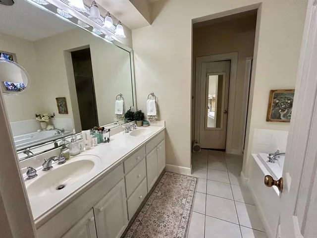 a bathroom with a double vanity sink a mirror and a shower