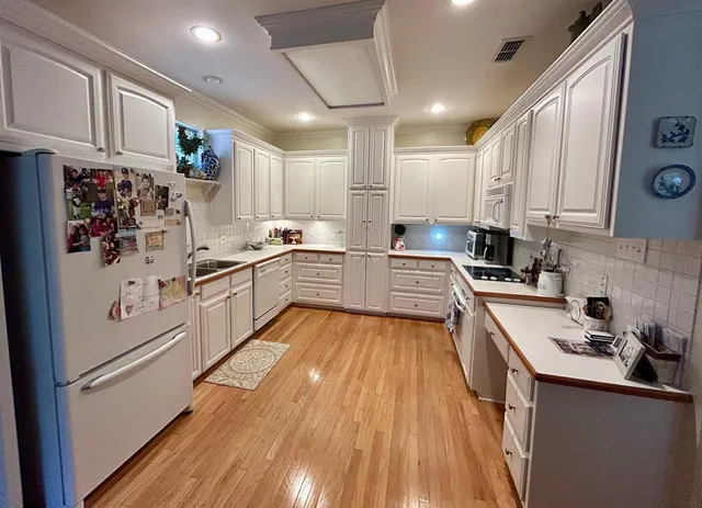 a kitchen with white cabinets and white appliances