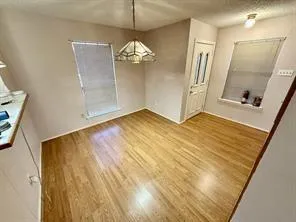 an empty room with wooden floor and mirror