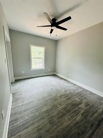 an empty room with a ceiling fan and window