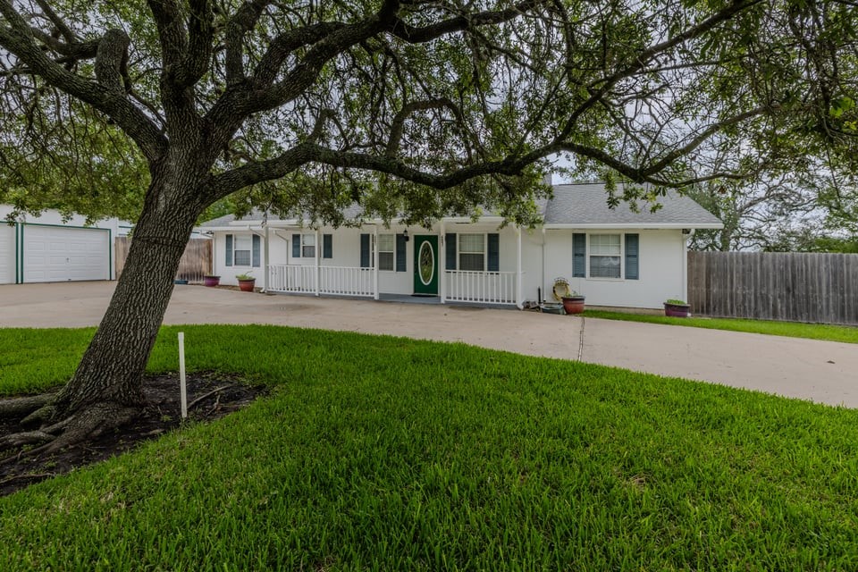 483 Riverside Drive Palacios, TX 77465 - Photo 2 of 41 a front view of house with a garden and trees