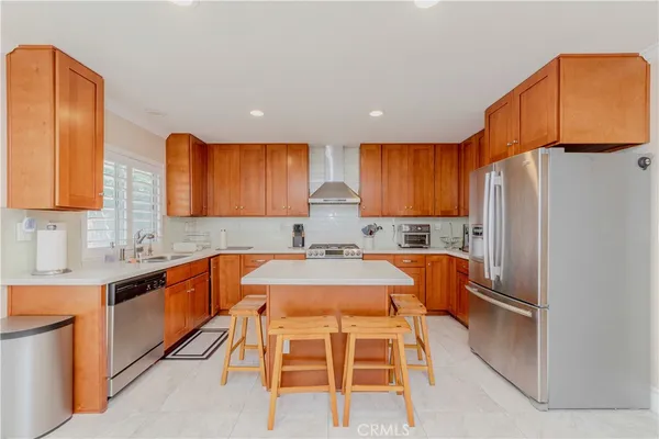 a kitchen with granite countertop a refrigerator and wooden cabinets