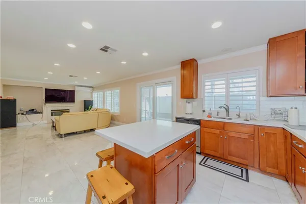 a view of a kitchen with kitchen island a sink stainless steel appliances and furniture
