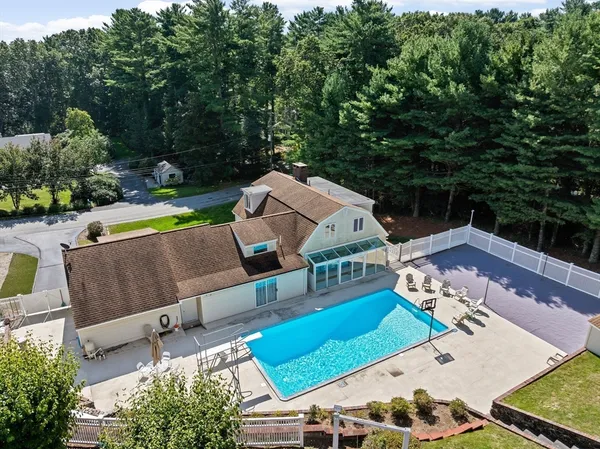 an aerial view of a house with swimming pool and a yard