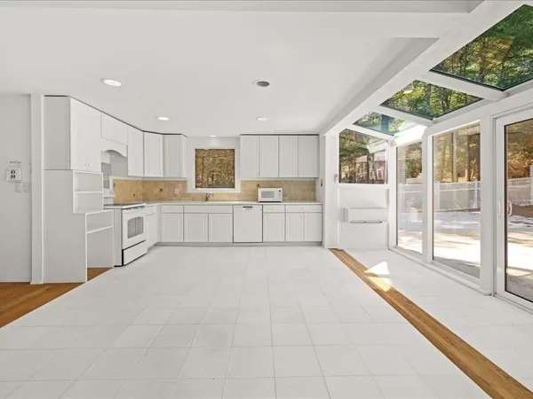 a kitchen with white cabinets and white appliances