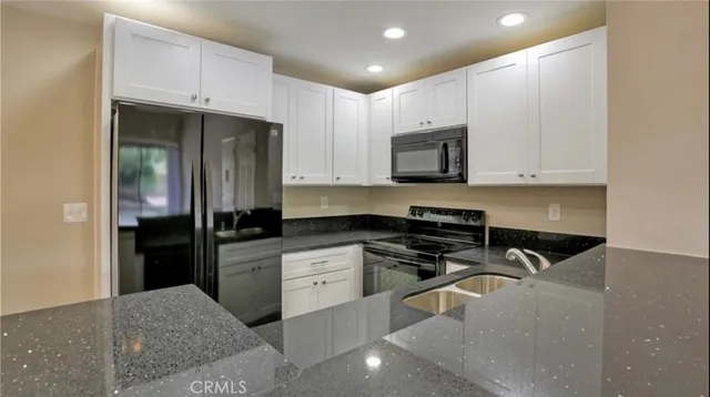 a kitchen with stainless steel appliances granite countertop a refrigerator stove a sink and dishwasher