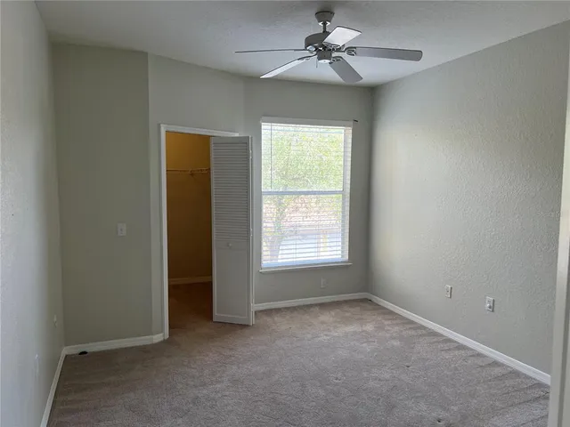 a view of room with a ceiling fan and a window
