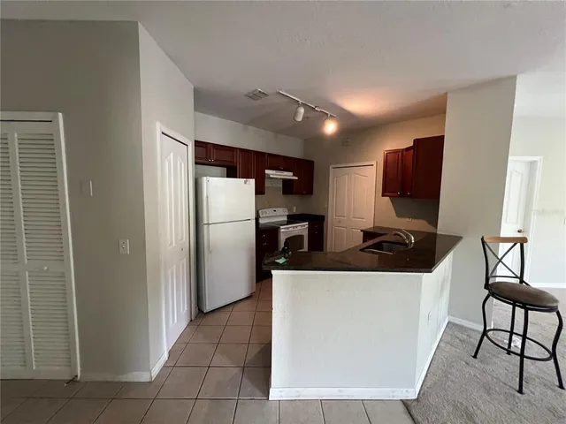 a kitchen with stainless steel appliances granite countertop a refrigerator a stove a sink and a refrigerator with wooden floor