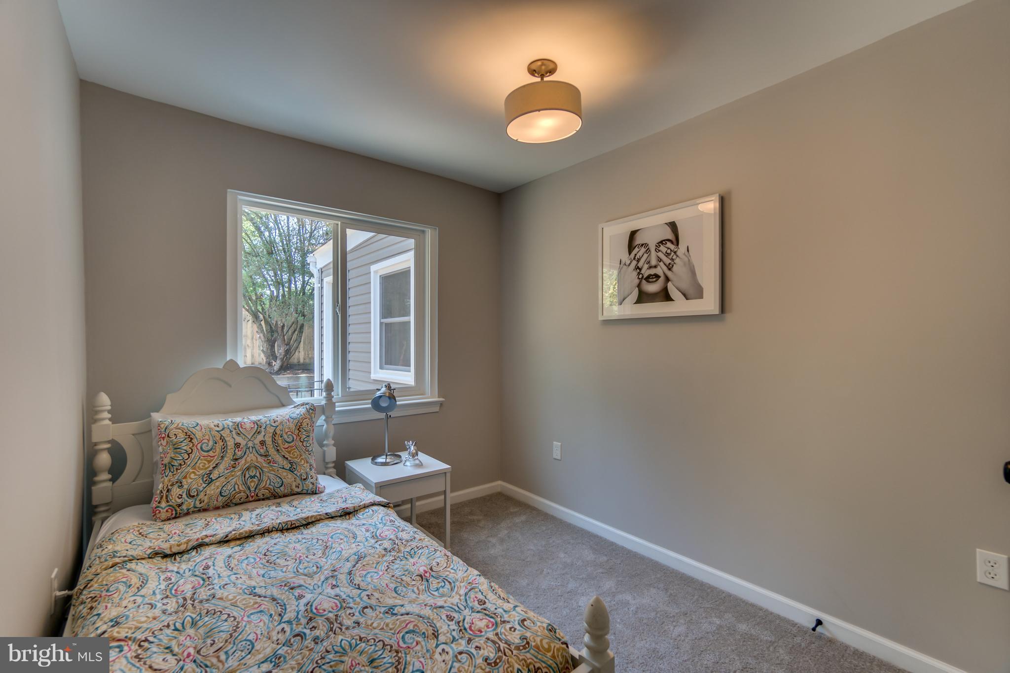 11517 Mapleview Drive Silver Spring, MD 20902 - Photo 13 of 18 a bedroom with a bed and a chandelier
