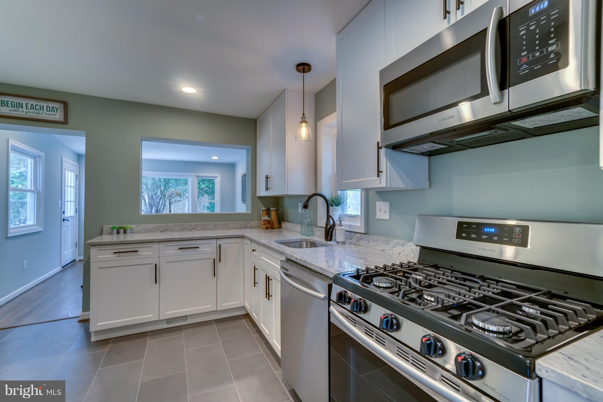 11517 Mapleview Drive Silver Spring, MD 20902 - Photo 9 of 18 a kitchen with stainless steel appliances granite countertop a stove and a sink