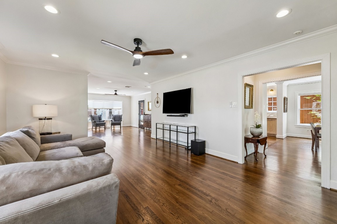 1925 Banks Street Houston, TX 77098 - Photo 11 of 38 The living room connects seamlessly to the dining area and kitchen, creating an open and inviting atmosphere. A wall-mounted TV and neutral decor enhance the modern feel.