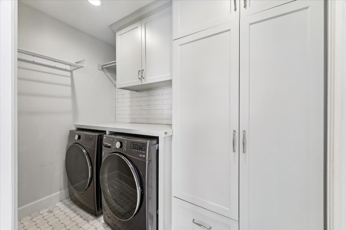 1925 Banks Street Houston, TX 77098 - Photo 15 of 38 This first floor laundry room is sleek and modern, featuring side-by-side front-loading washer and dryer, ample cabinetry for storage, a countertop for folding, and a subway tile backsplash for a clean look.
