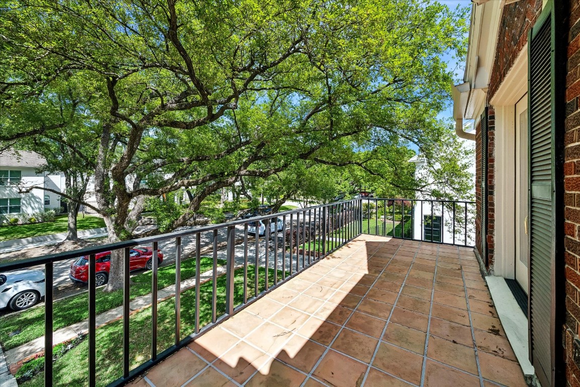 1925 Banks Street Houston, TX 77098 - Photo 19 of 38 The charming balcony with terracotta tiles, offering a view of a tree-lined street. The balcony provides a serene outdoor space with ample natural light.