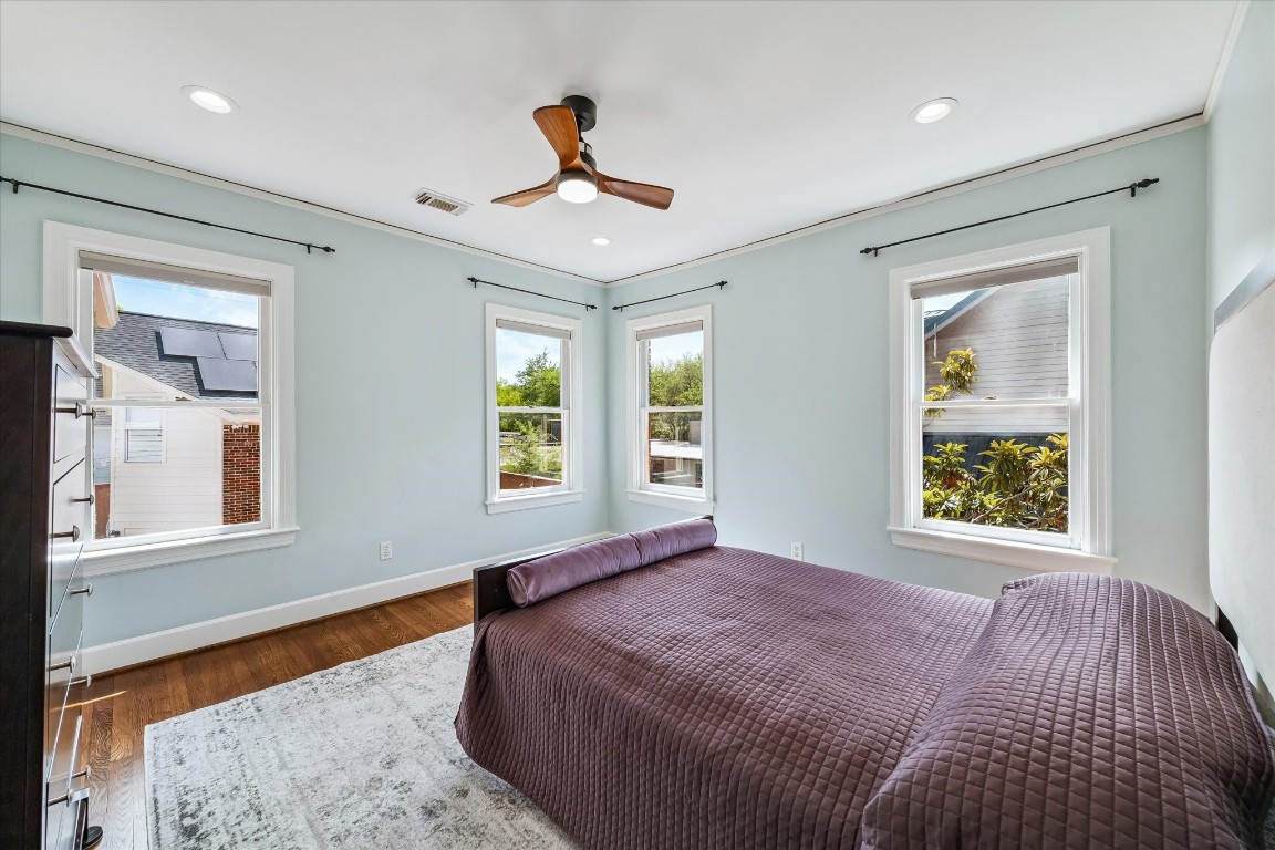 1925 Banks Street Houston, TX 77098 - Photo 24 of 38 Welcome to the secondary bedroom across the hall with relaxing light blue walls, hardwood floors, and three large windows allowing for plenty of natural light.