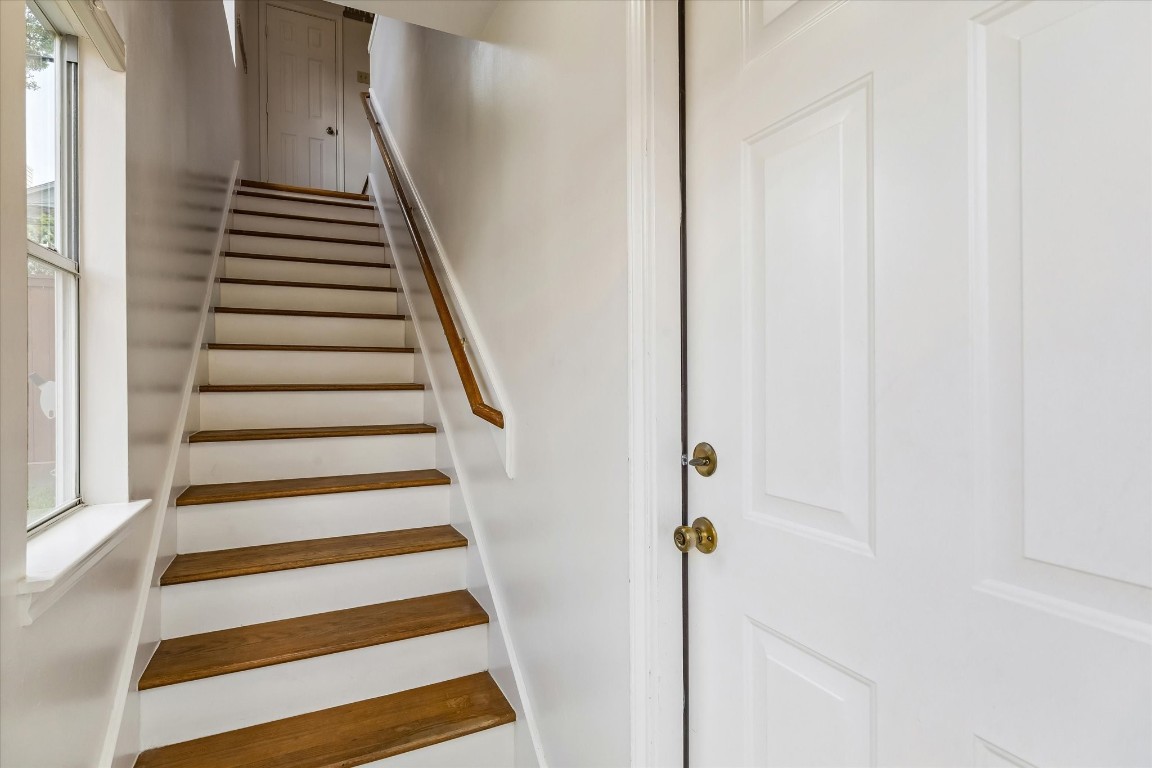 1925 Banks Street Houston, TX 77098 - Photo 29 of 38 This photo shows the bright staircase leading up to a spacious garage apartment with a full kitchen. A window on the left allows natural light to filter in, highlighting the clean, minimalist design.