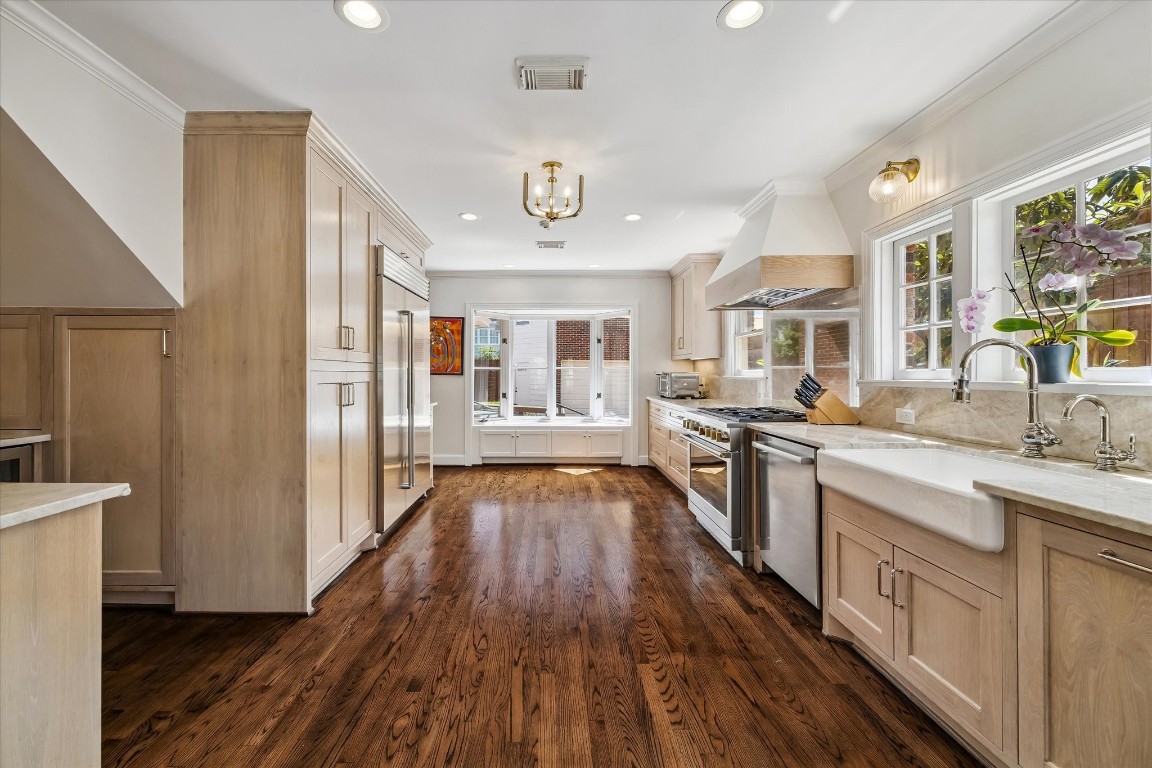 1925 Banks Street Houston, TX 77098 - Photo 6 of 38 right off of the dining room you are welcomed into this newly remodeled kitchen. Featuring elegant wooden cabinetry and flooring, Taj Mahal Quartzite countertops, Sub Zero (48”) GM Monogram 6 burner gas stove, Bosch dishwasher and ceramic farmers sink.