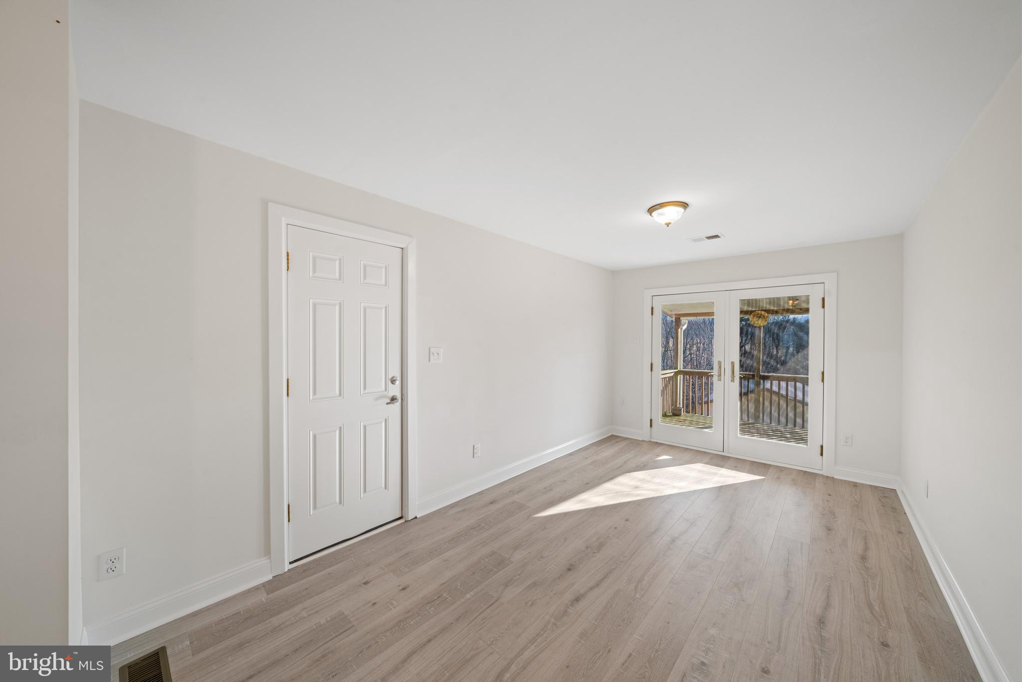 5209 Woodville Road Mount Airy, MD 21771 - Photo 11 of 90 an empty room with wooden floor and windows