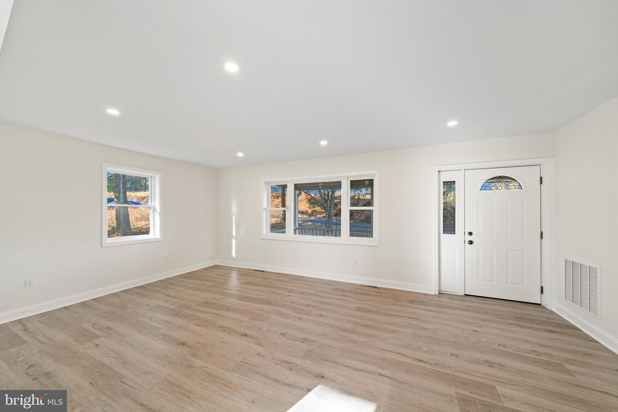 5209 Woodville Road Mount Airy, MD 21771 - Photo 19 of 90 a view of an empty room with wooden floor and windows