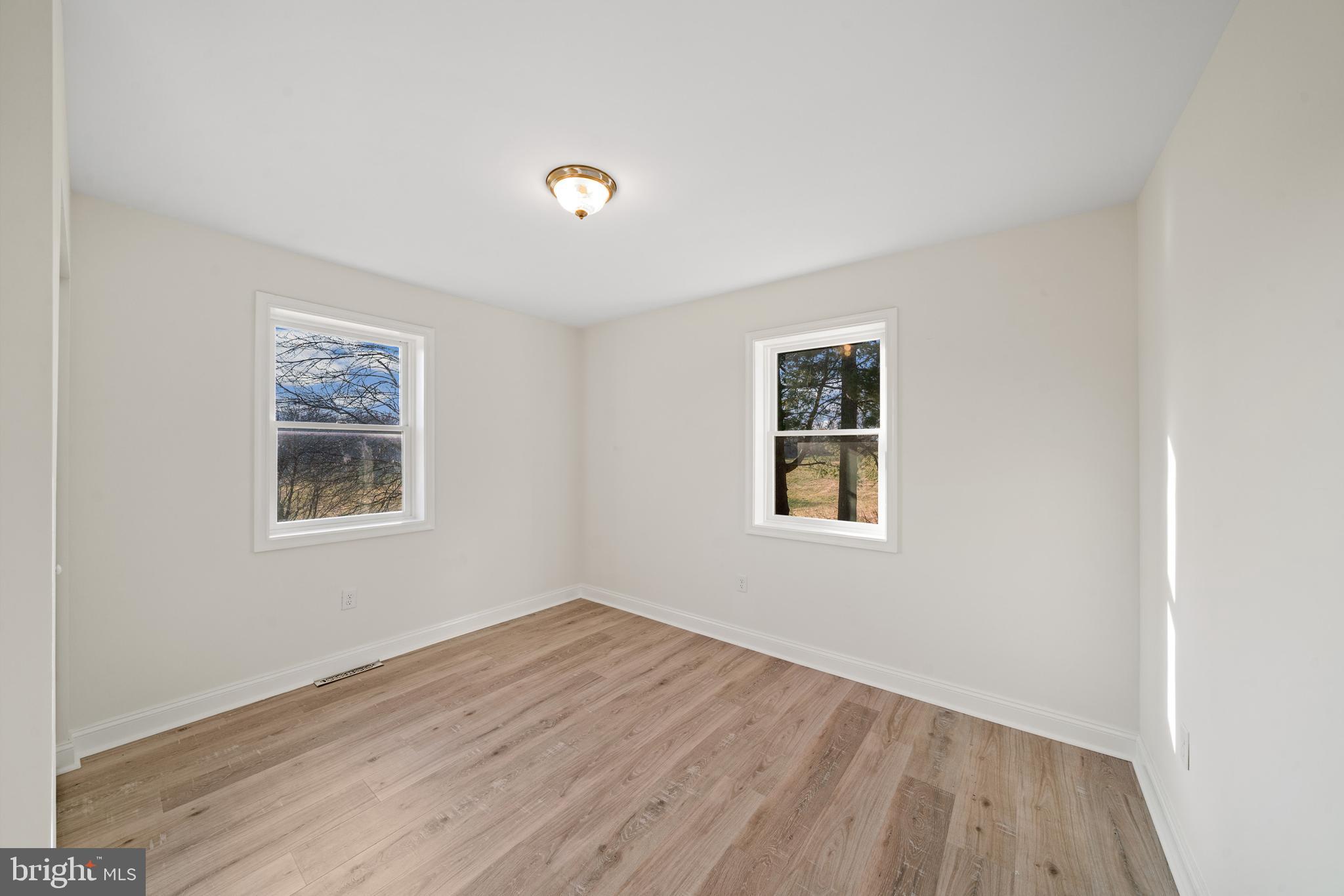 5209 Woodville Road Mount Airy, MD 21771 - Photo 25 of 90 a view of an empty room with wooden floor and a window