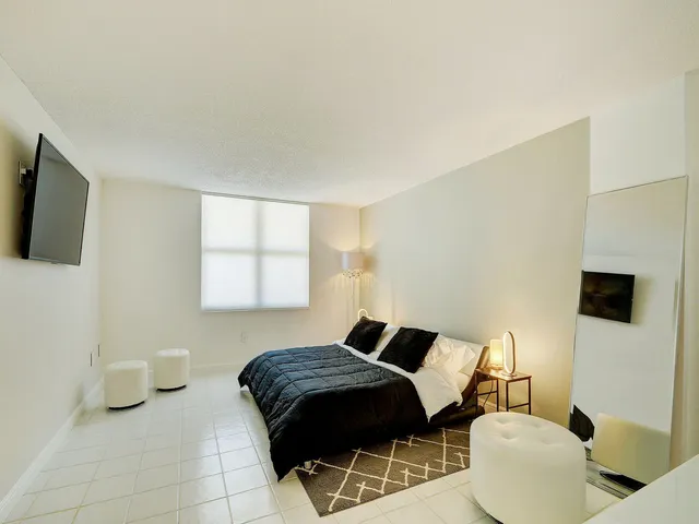 a bedroom with a bed and a flat screen tv