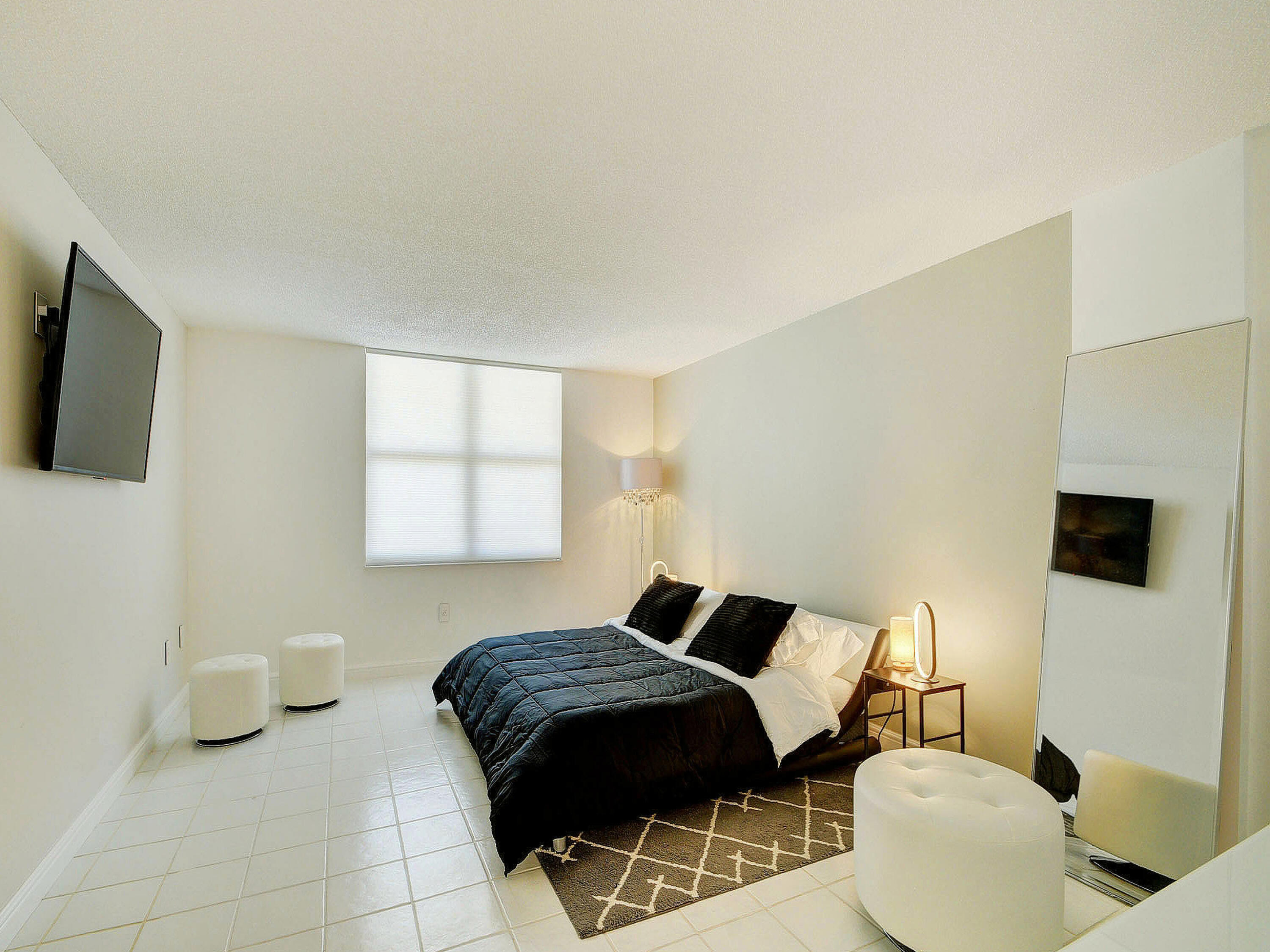 3460 South Ocean Boulevard, Unit 7110 Palm Beach, FL 33480 - Photo 14 of 23 a bedroom with a bed and a flat screen tv