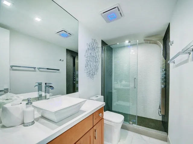 a bathroom with a sink a toilet a mirror and shower