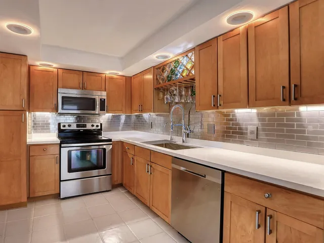 a kitchen with granite countertop a sink and a stove top oven with wooden floor