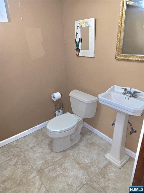 585 Monroe Place Ridgefield, NJ 07657 - Photo 23 of 28 a white toilet sitting next to a bathroom sink