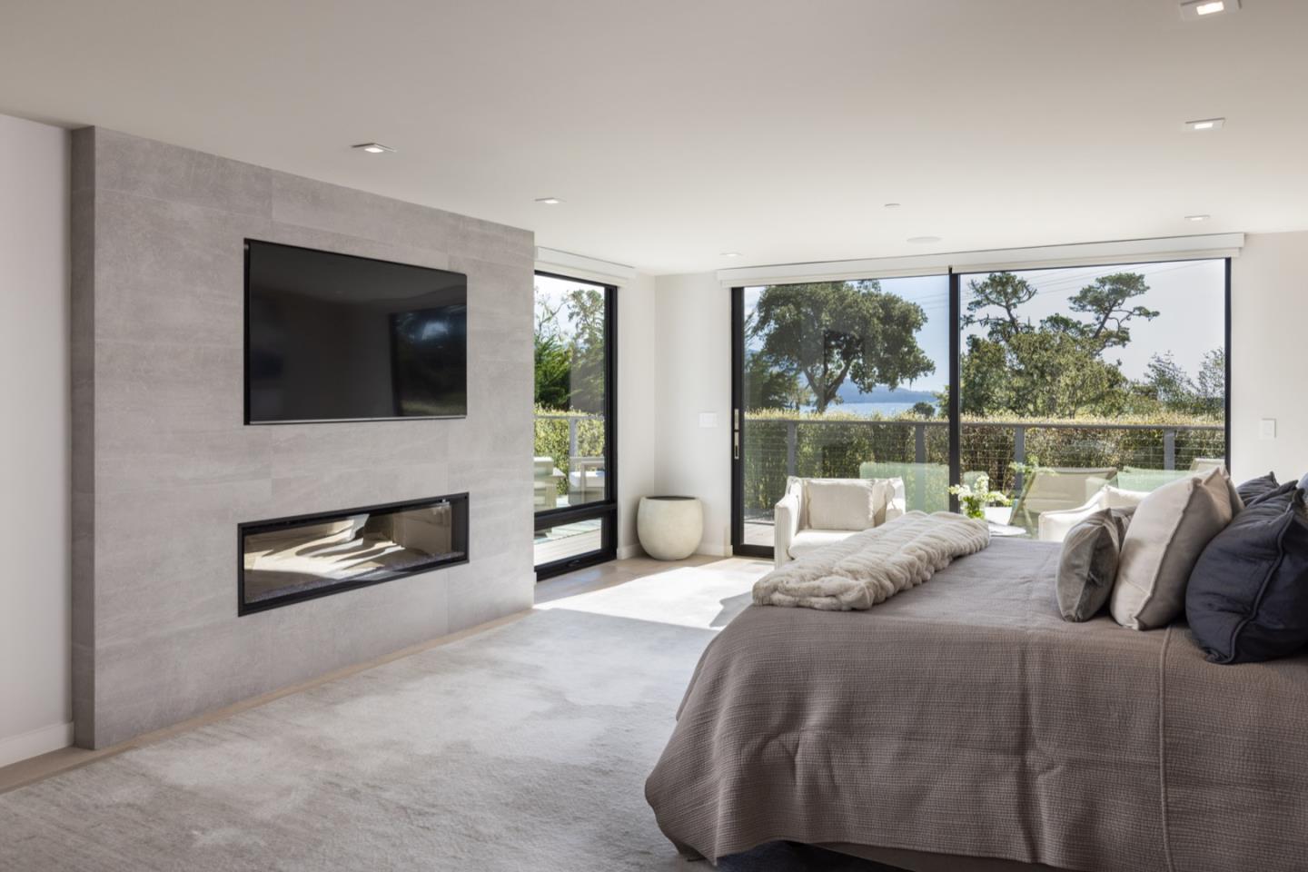 1505 Venadero Road Pebble Beach, CA 93953 - Photo 21 of 34 a bedroom with a bed a flat screen tv and a floor to ceiling window