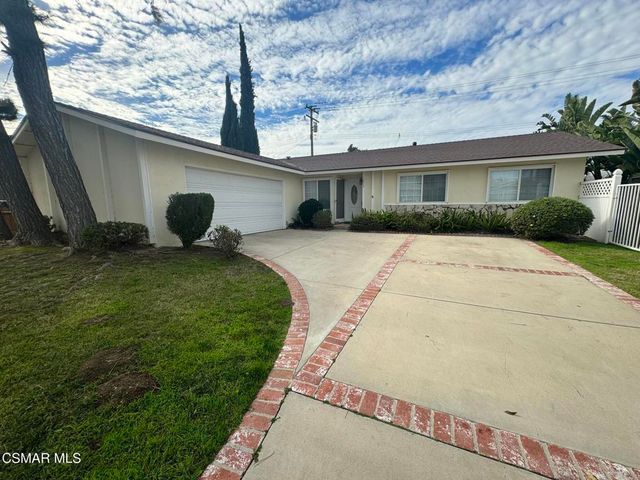 a front view of a house with a yard and potted plants