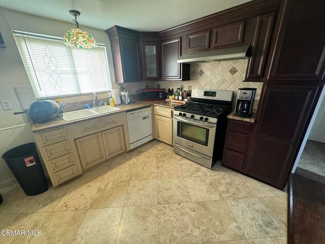 a kitchen with stainless steel appliances granite countertop a sink stove and cabinets