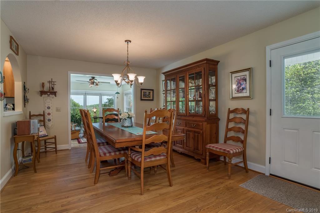 433 Meadow Crest Road Tryon, NC 28782 - Photo 12 of 29 a dining room with furniture a chandelier and wooden floor