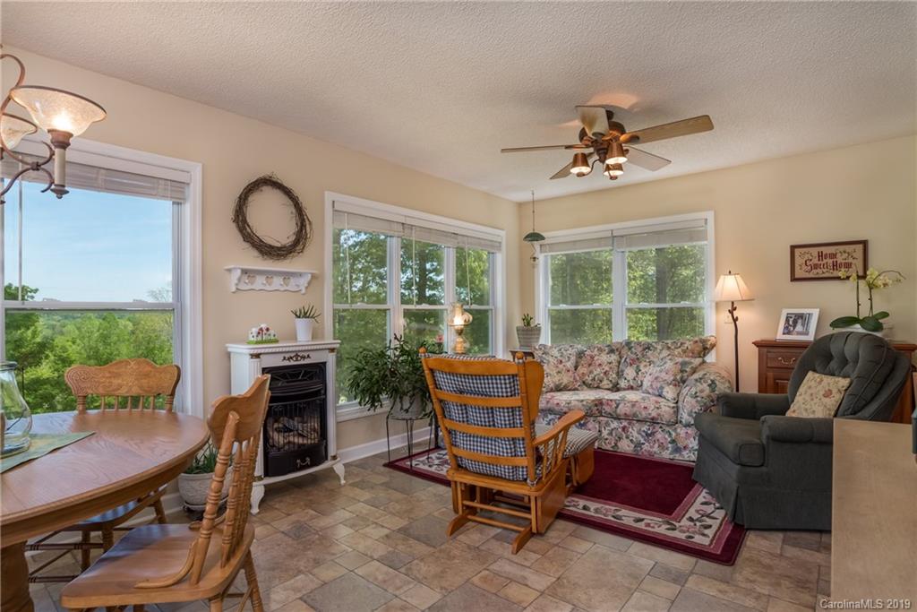 433 Meadow Crest Road Tryon, NC 28782 - Photo 16 of 29 a living room with furniture a fireplace and a floor to ceiling window