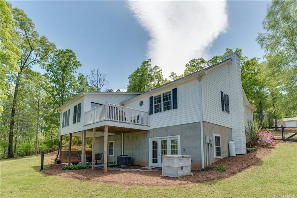 433 Meadow Crest Road Tryon, NC 28782 - Photo 4 of 29 a view of a white house with large windows and a small yard